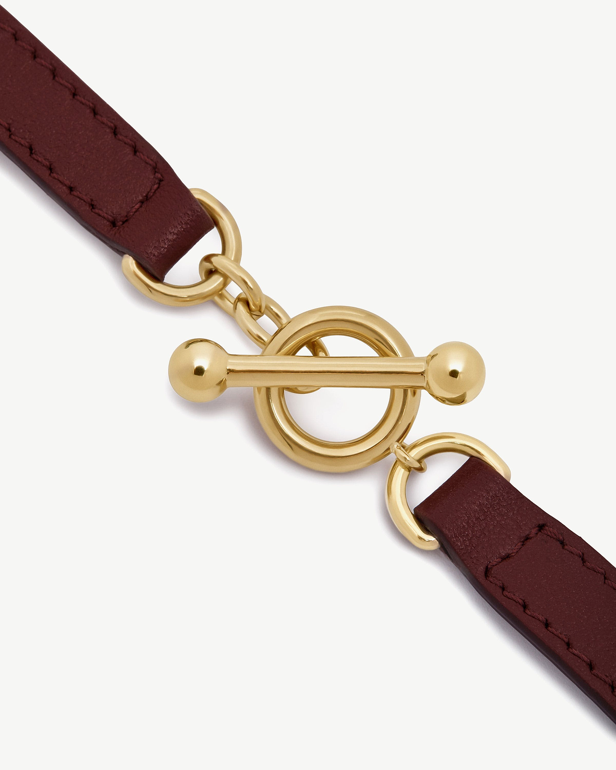 Oxblood leather kite bracelet with polished gold toggle clasp close-up
