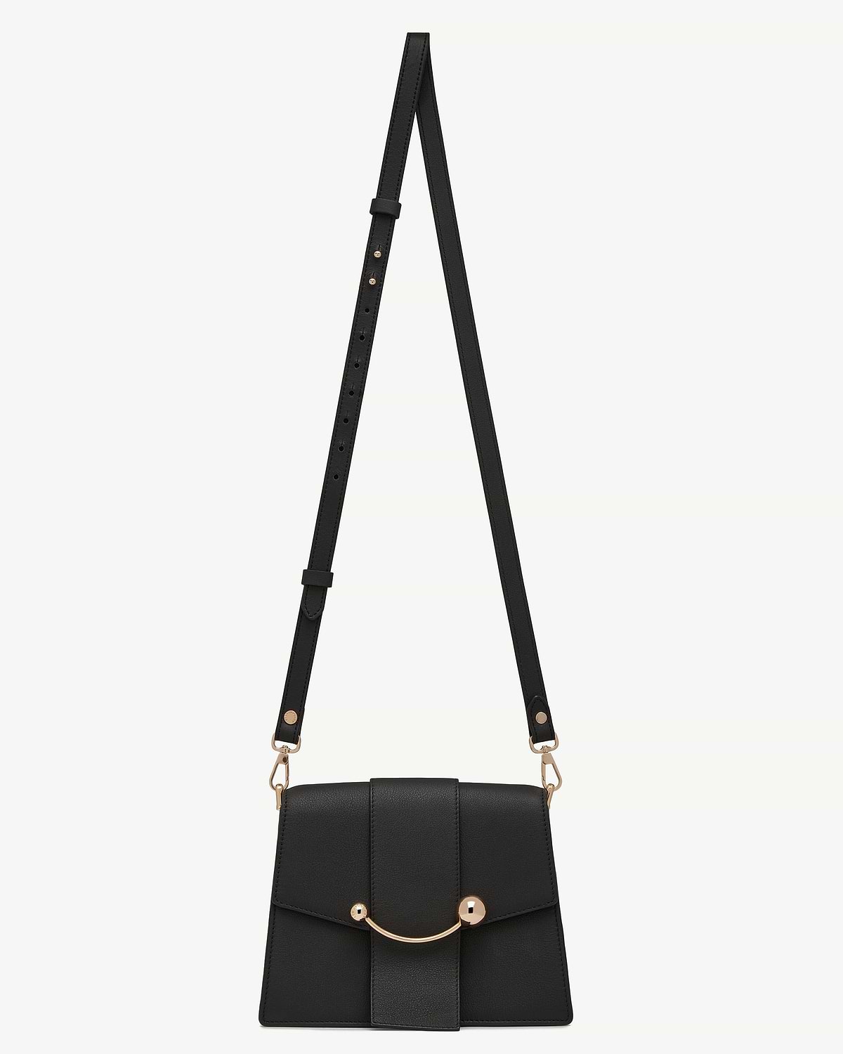 Black thin adjustable leather strap attached to small black crossbody bag with gold hardware