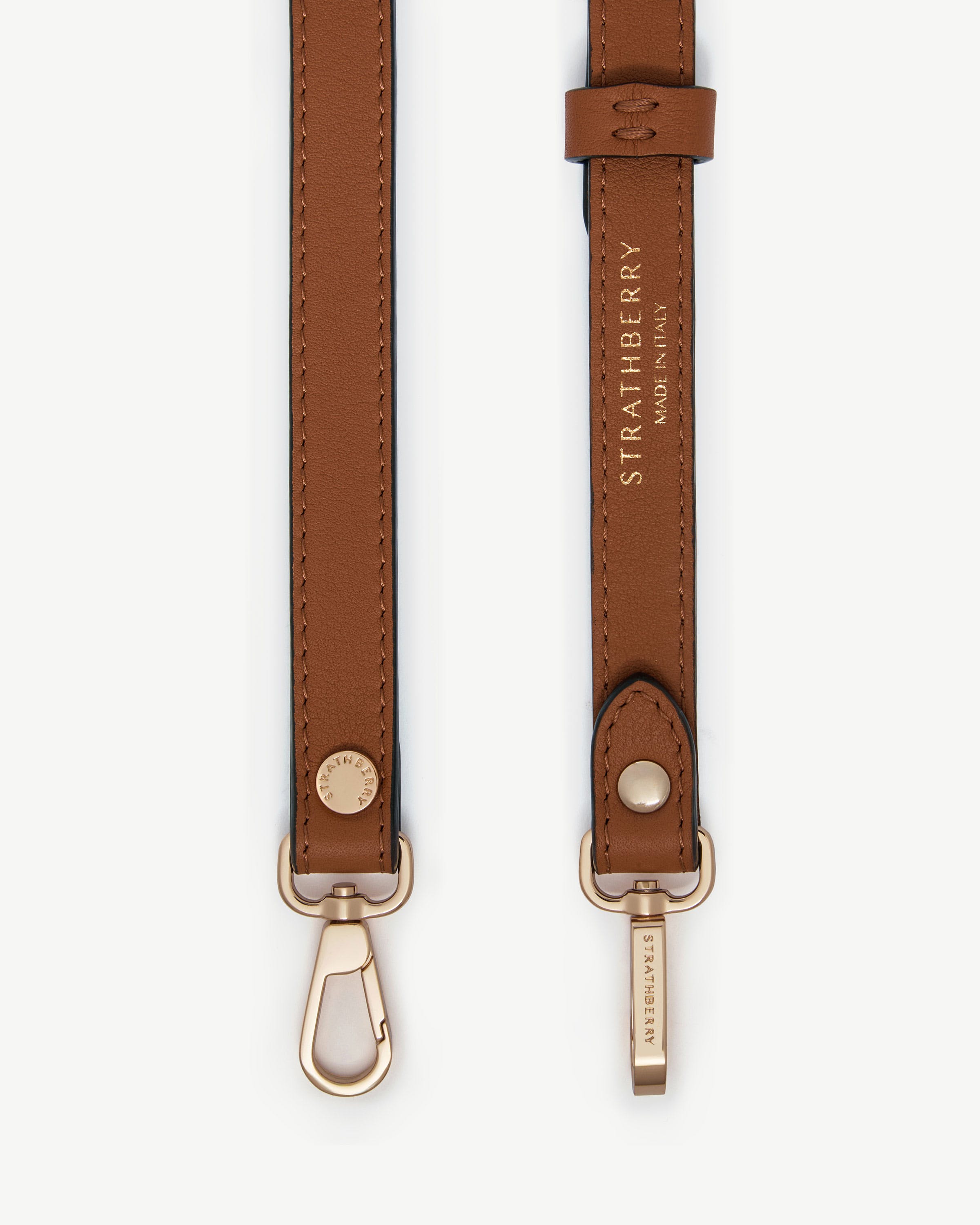 Chestnut thin adjustable leather strap with gold hardware and Strathberry logo.