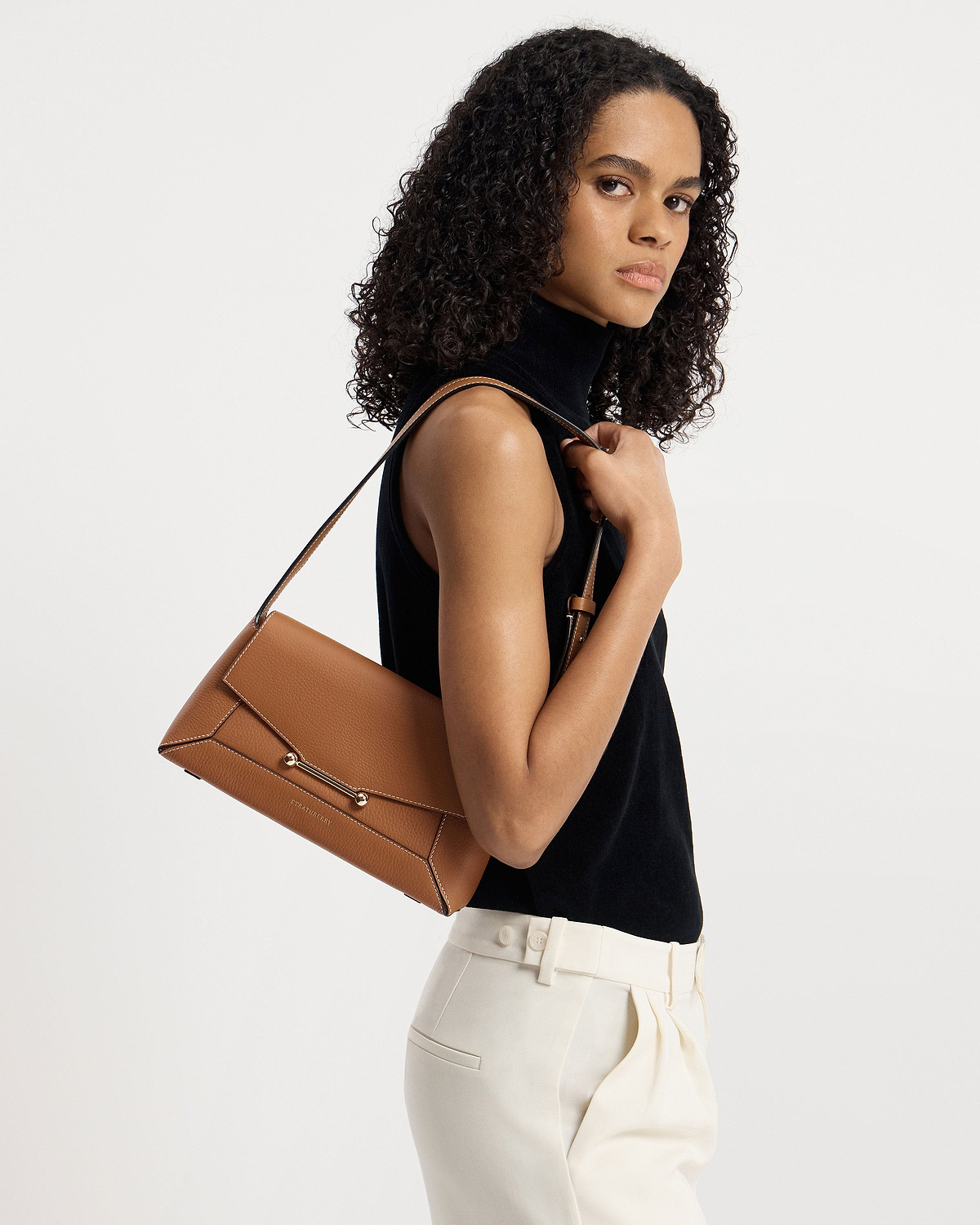 Model carrying tan Strathberry Mosaic Shoulder bag on her shoulder.