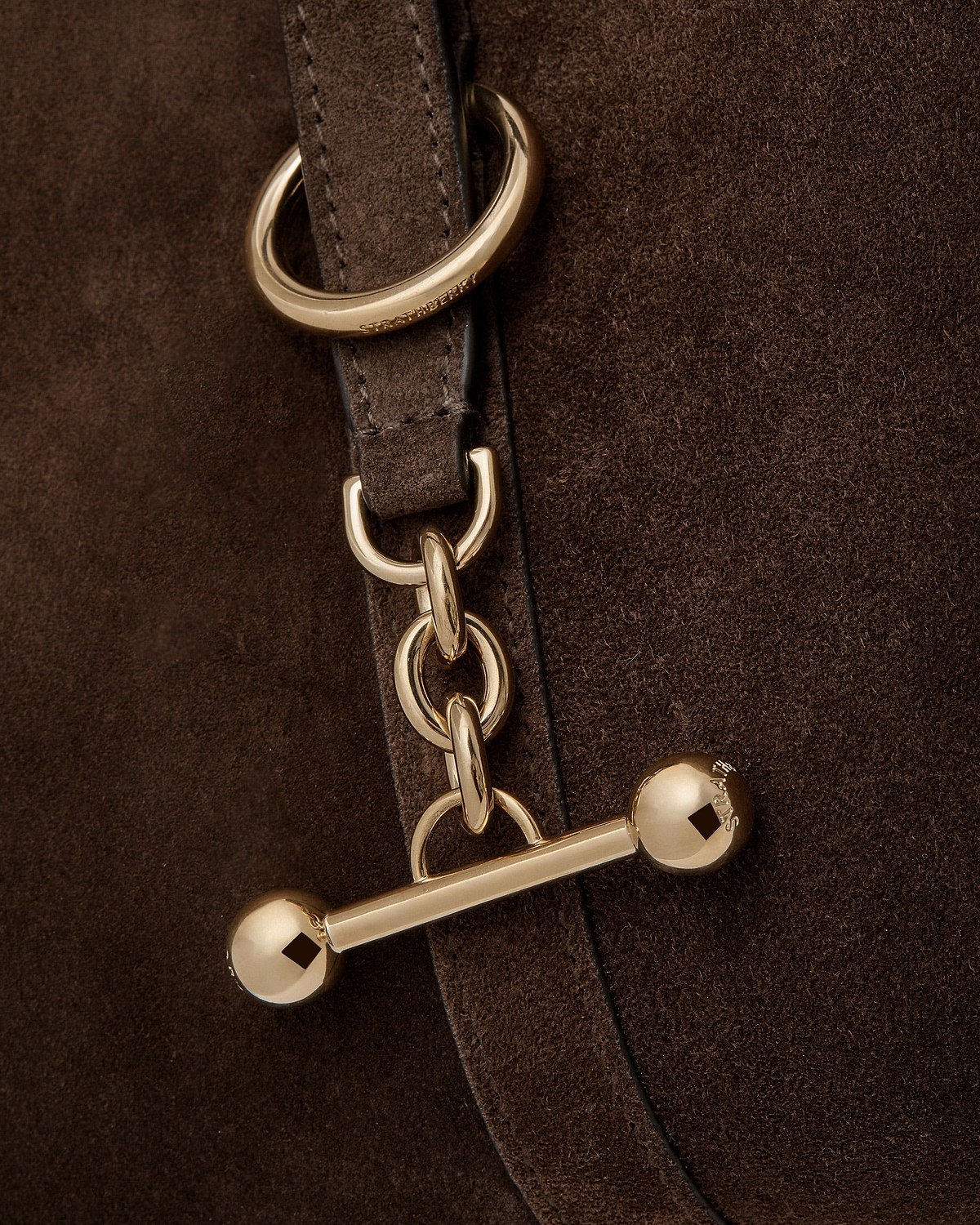 Chocolate suede bag strap with gold chain hardware and Strathberry engraving.