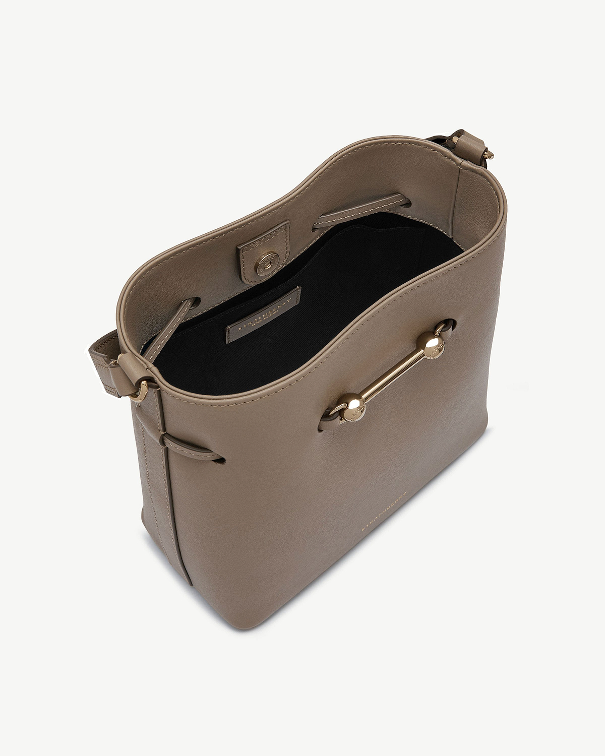 Taupe leather bucket bag with gold bar detail and black interior.