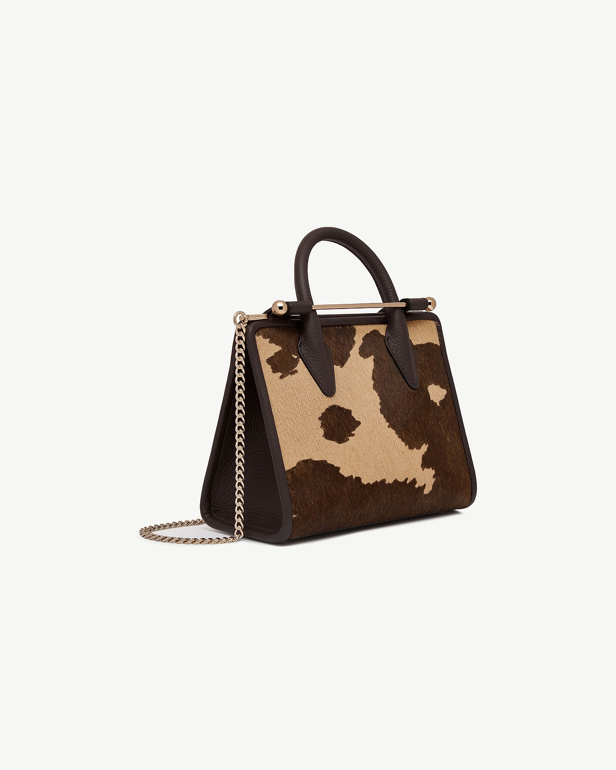 Mini tote with sand and espresso spot print, top handles and gold chain strap.