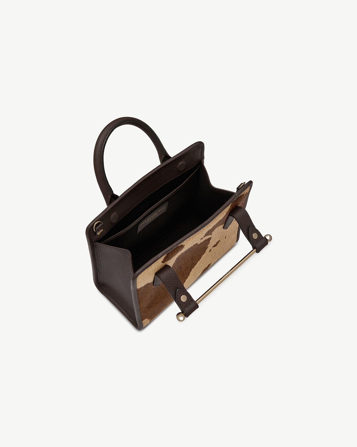 Mini tote with sand and espresso spot print, dark brown handles and gold bar.