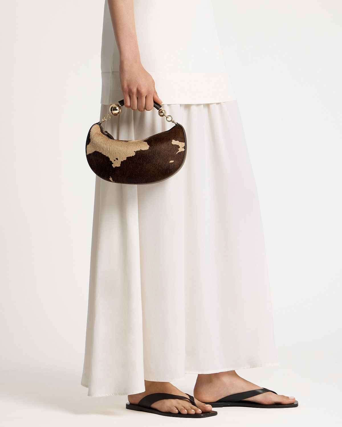 Crescent-shaped mini bag in sand and espresso spot print with gold ball handle.