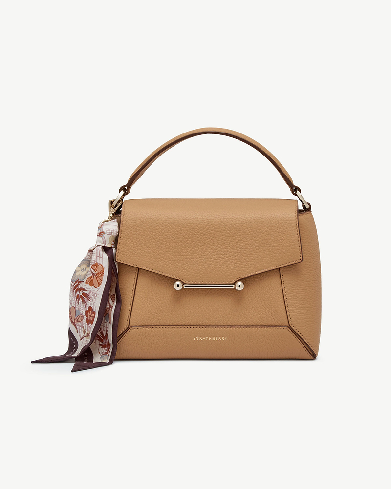 Silk charm scarf tied to tan Strathberry bag handle, Scottish Architecture Burgundy pattern.