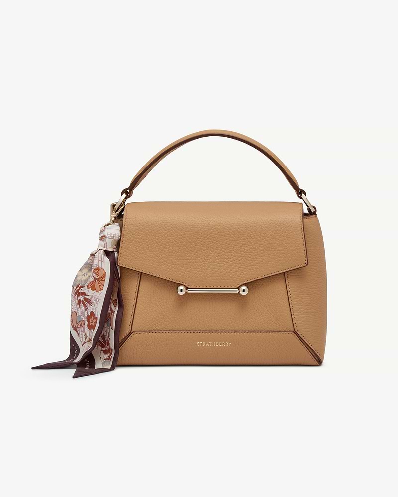 Silk charm scarf tied to tan Strathberry bag handle, Scottish Architecture Burgundy pattern.