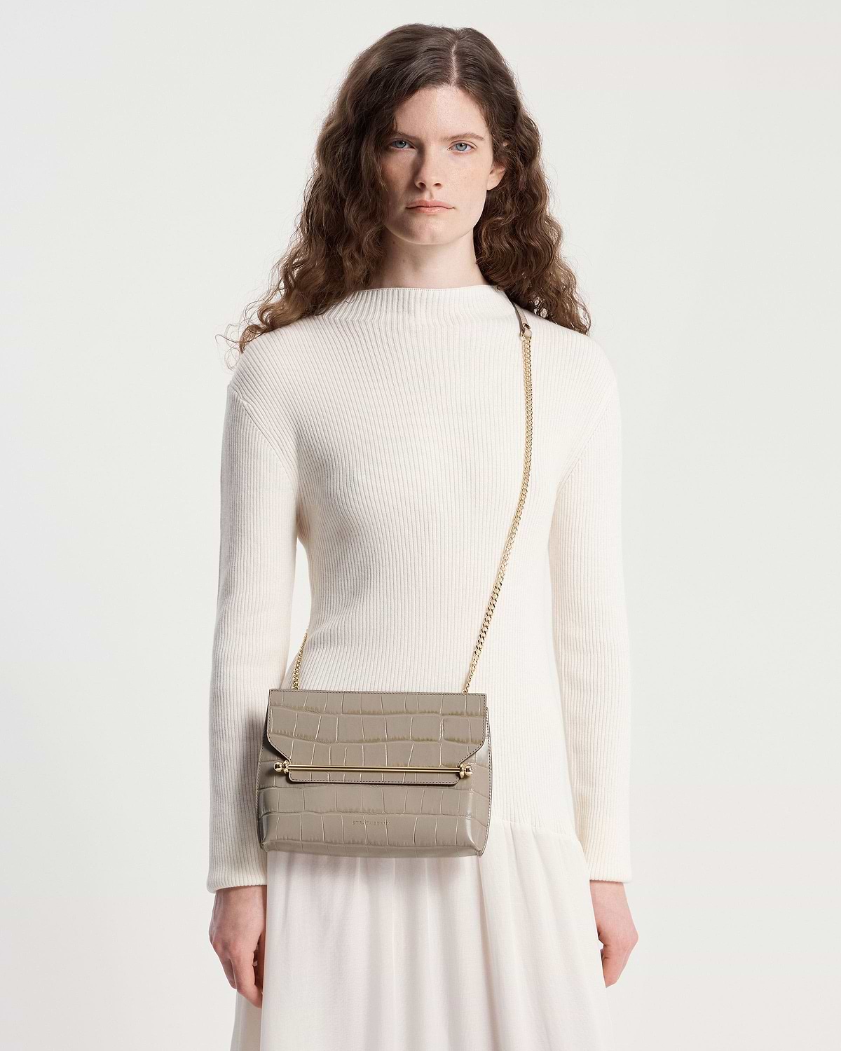 Model wearing cream ribbed top and taupe croc-effect stylist crossbody bag with gold chain strap