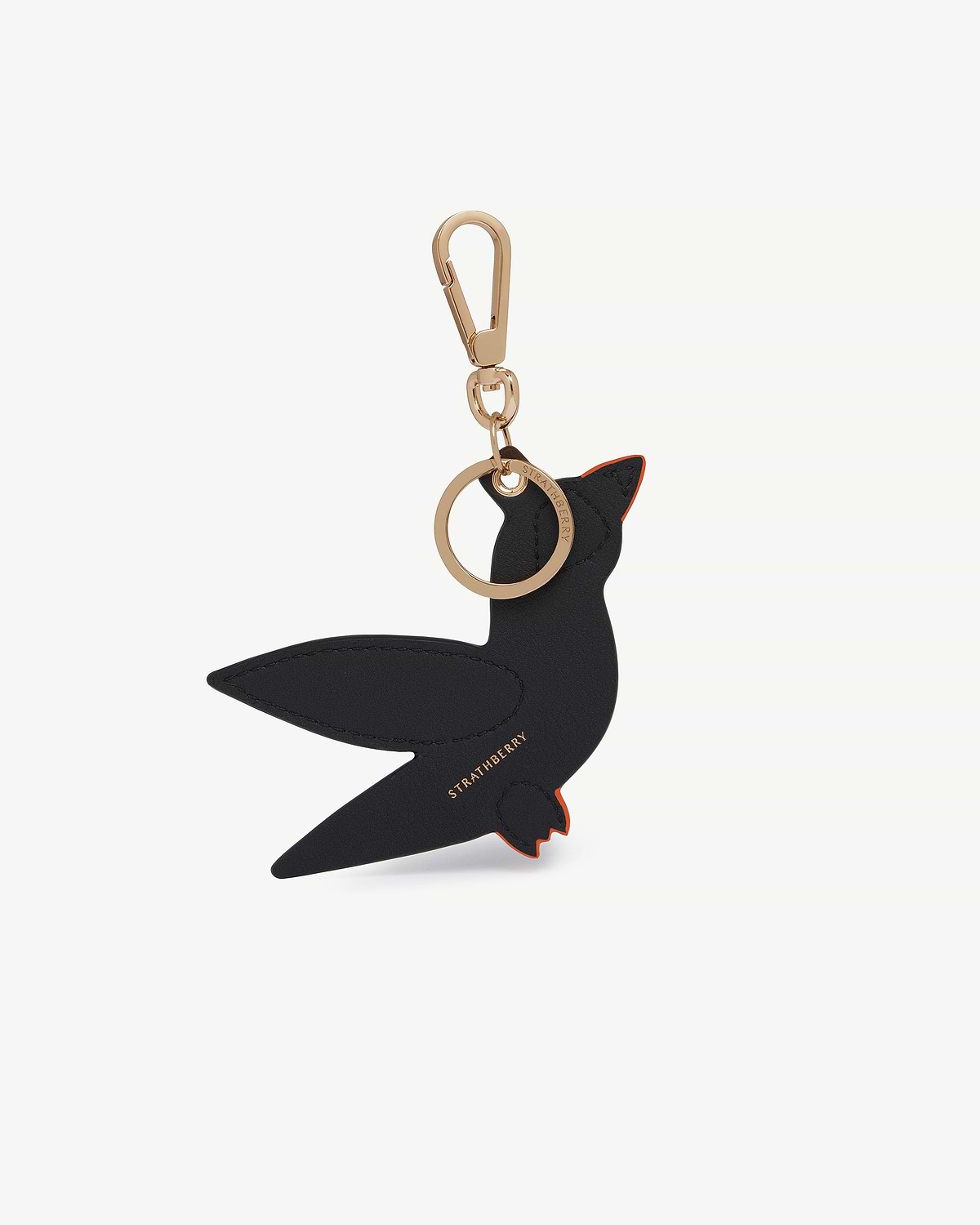 Black and orange leather bird bag charm with gold clasp and ring, Strathberry logo.