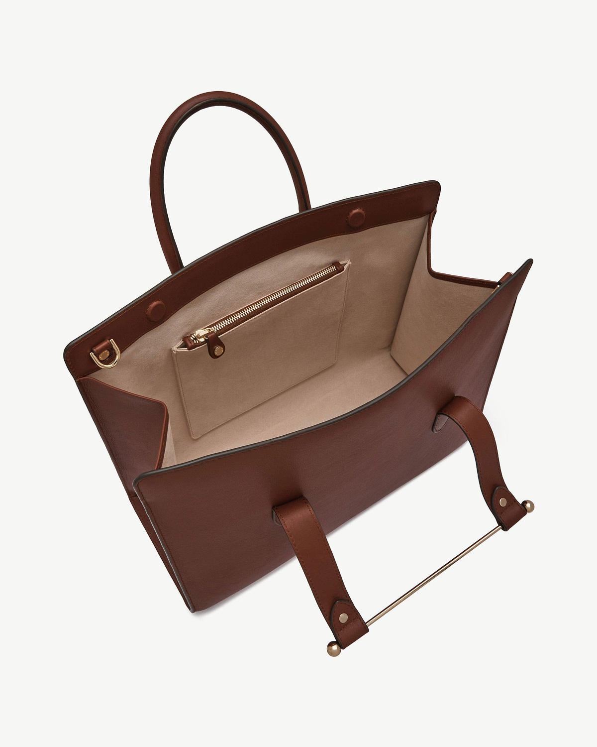 Open walnut leather tote showing beige interior, zip pocket, handles and gold hardware.