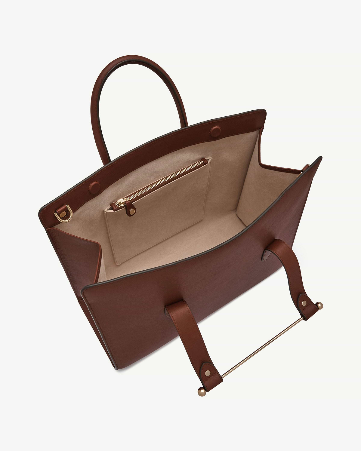 Open walnut leather tote showing beige interior, zip pocket, handles and gold hardware.