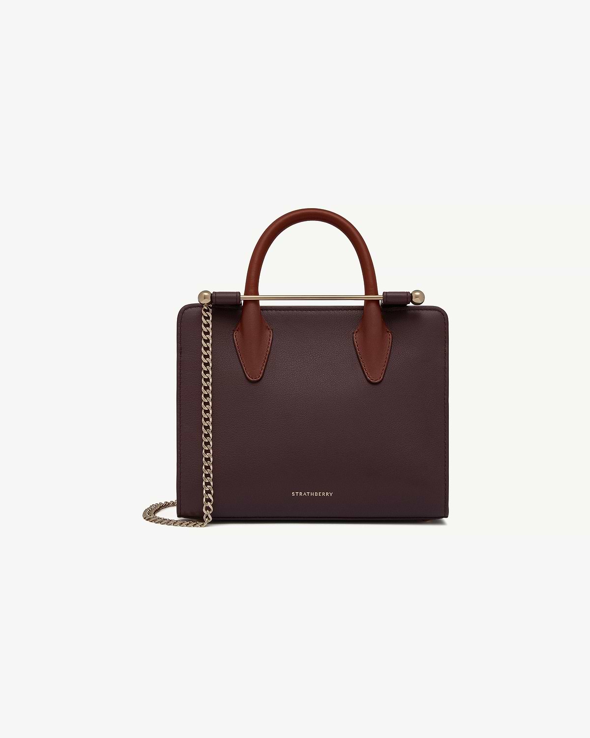 Strathberry burgundy mini tote with chestnut handles and gold chain strap.
