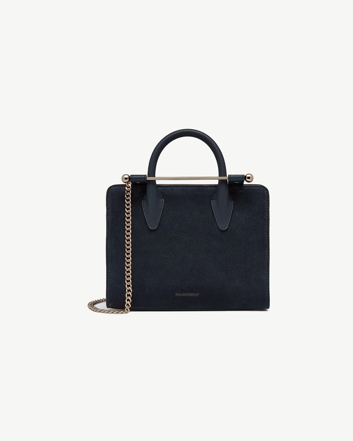 Navy suede mini tote with top handle, gold bar detail and chain strap.