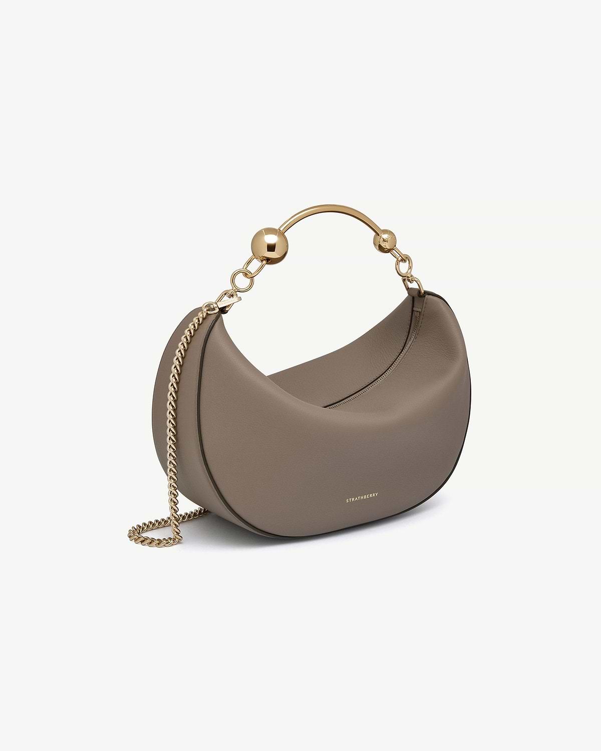 Taupe crescent-shaped leather bag with gold chain and Strathberry logo.