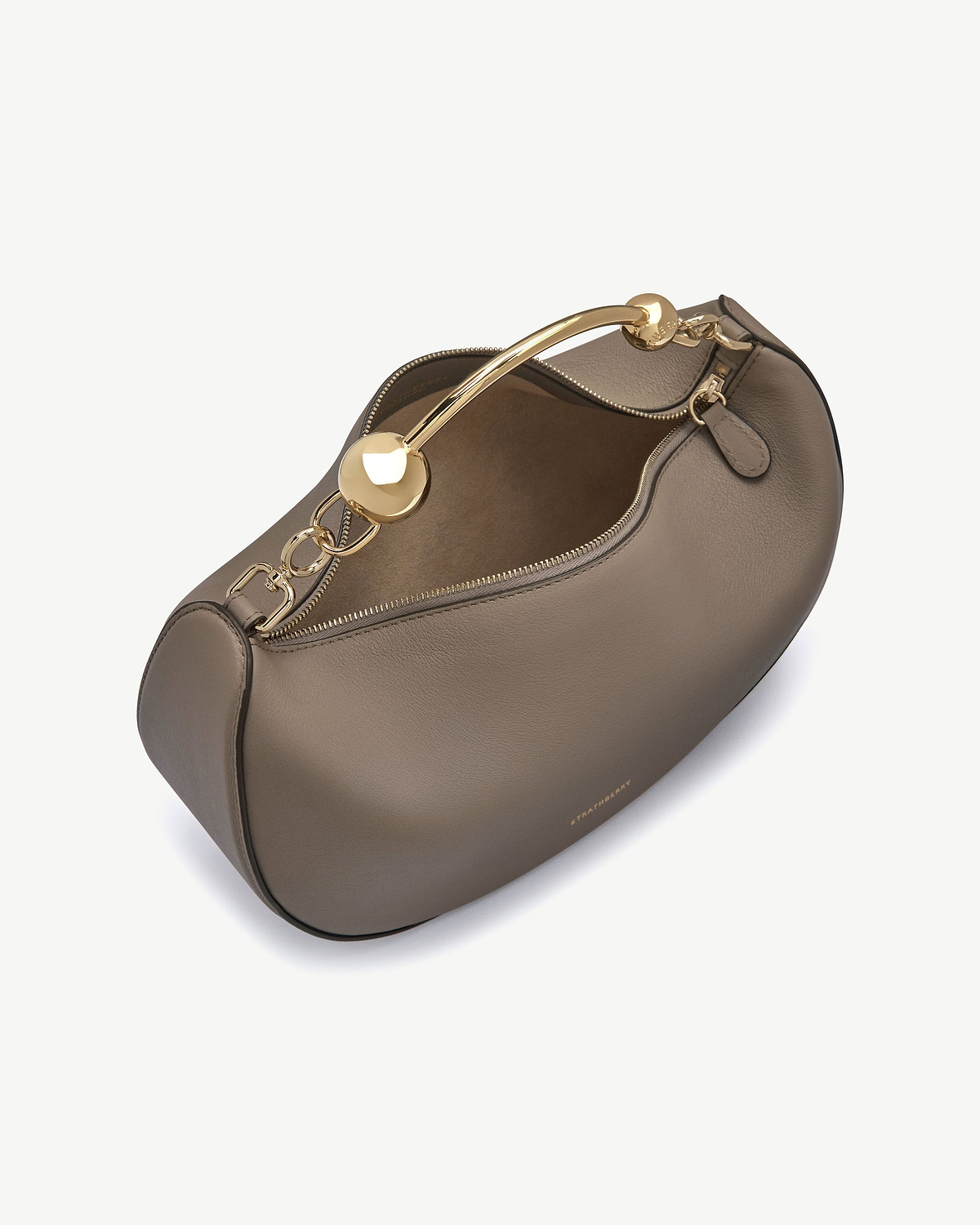 Taupe crescent moon bag with gold chain handle and visible Strathberry logo.