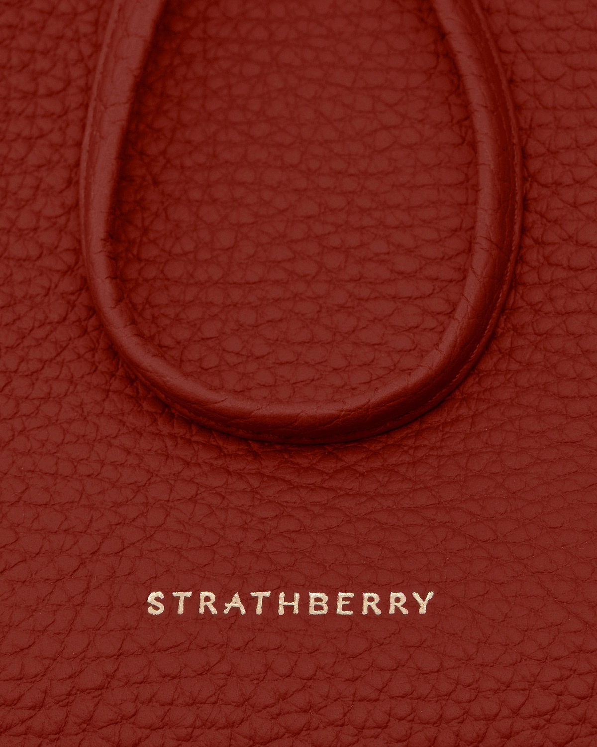 Levanto red textured leather with embossed Strathberry logo and rounded trim