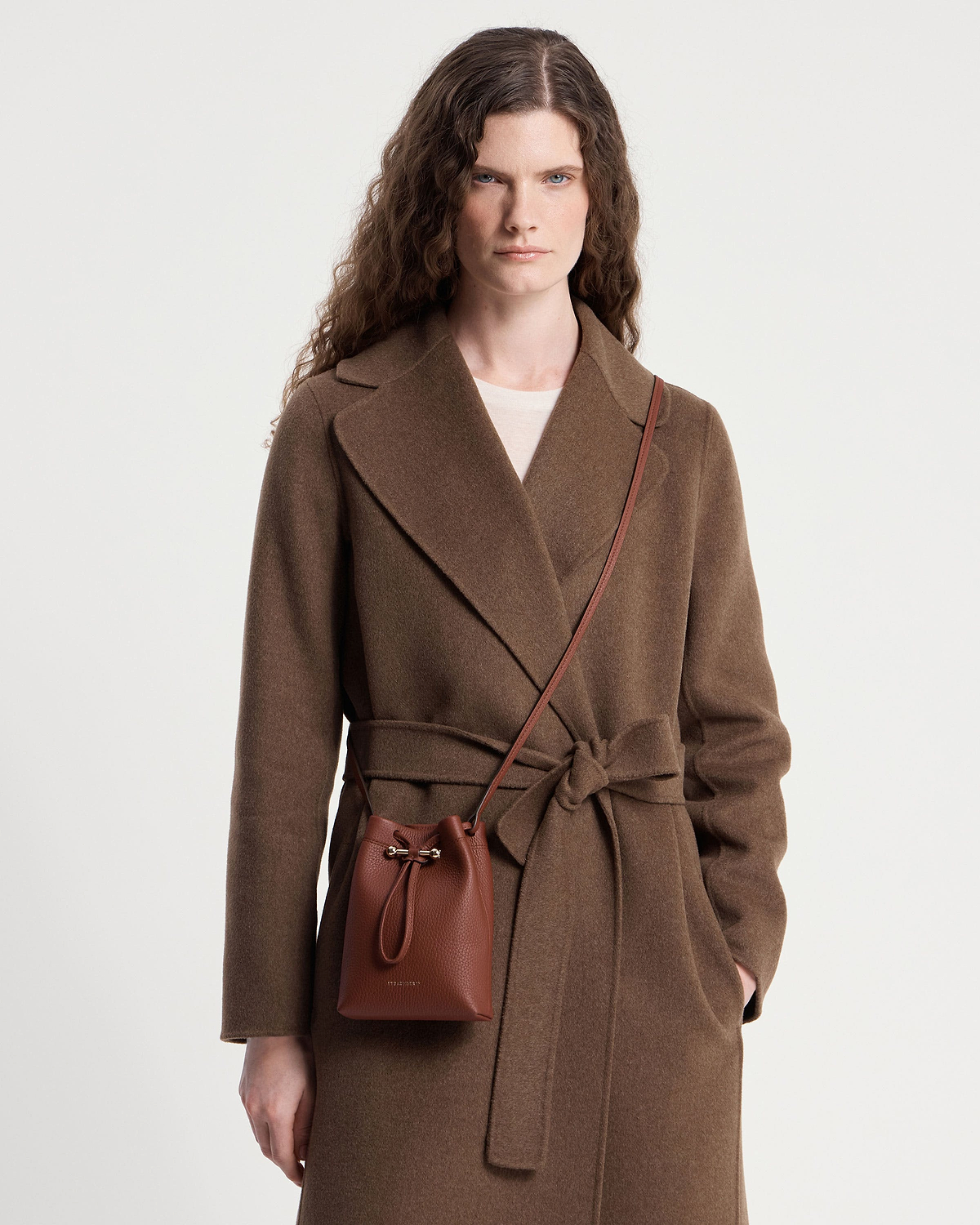 Model wearing brown coat with walnut Osette midi pouch crossbody bag.