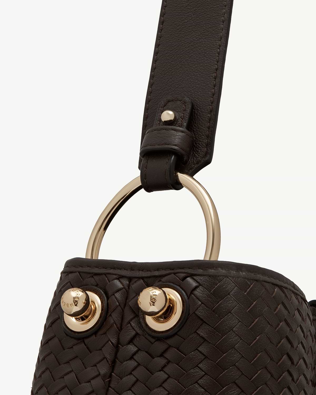 Chocolate woven leather strap with gold ring and stud hardware.