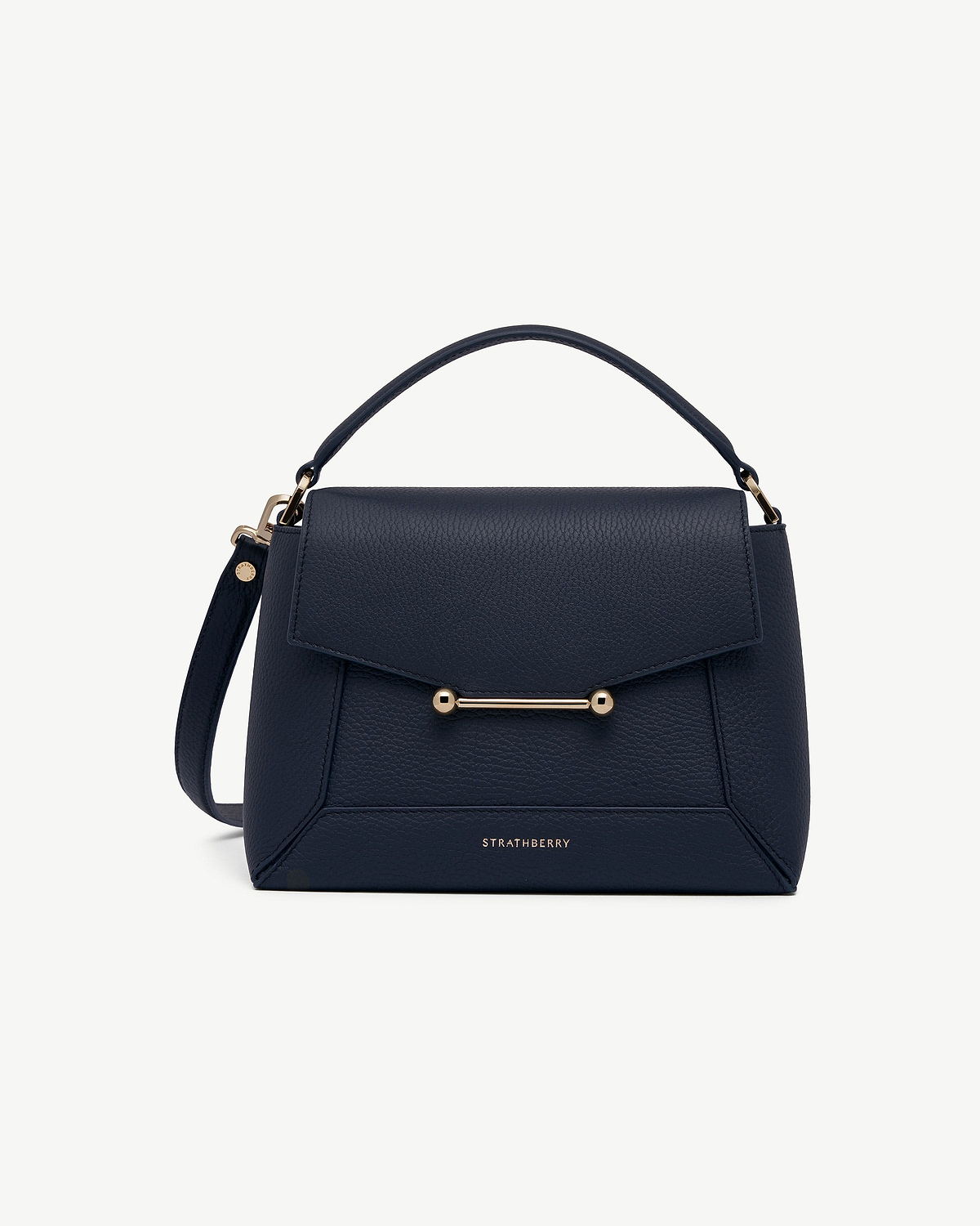 Strathberry navy mosaic bag with top handle, flap and gold bar detail.
