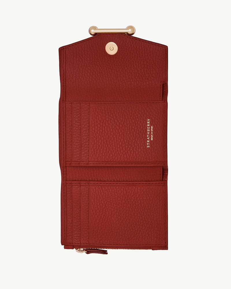 Strathberry Levanto red trifold wallet open, showing card slots and zip pocket.