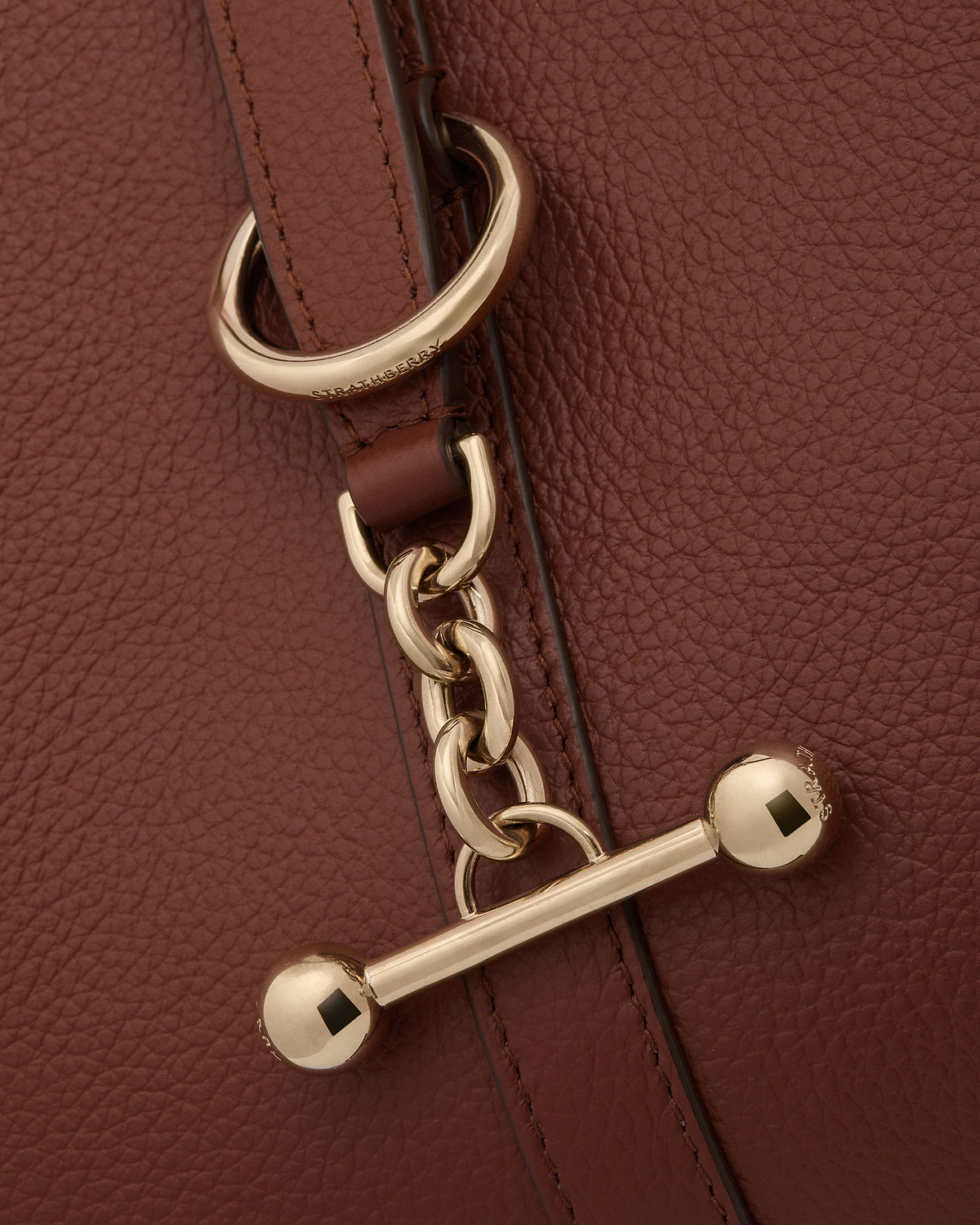 Walnut pebbled leather kite hobo strap with gold Strathberry hardware.