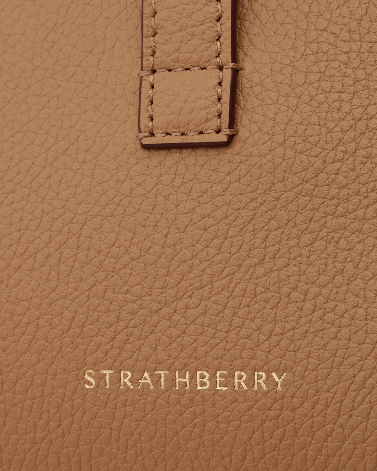 Caramel pebbled leather with stitched strap detail and gold Strathberry logo.