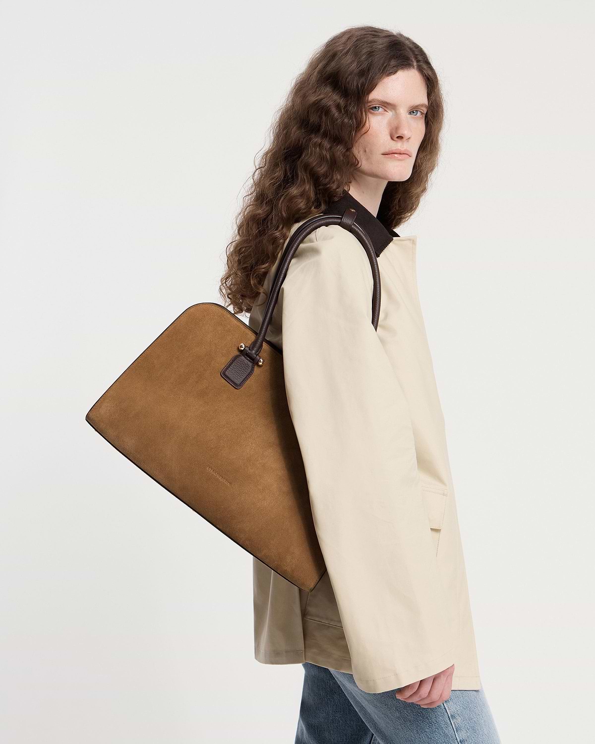 Model carrying a toffee suede and espresso leather tote over her shoulder.