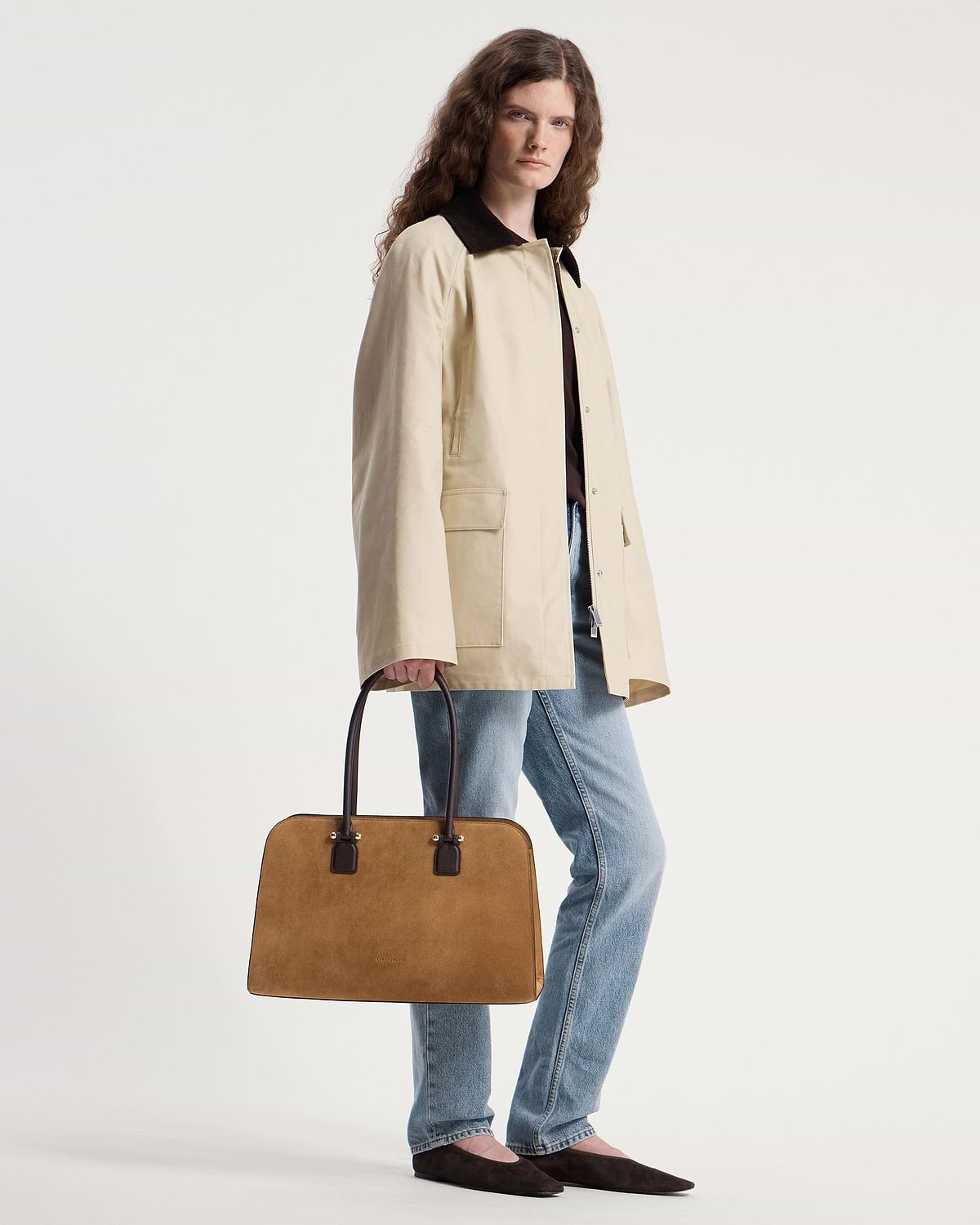 Model holding Strathberry Georgia Maxi bag in toffee suede with espresso handles