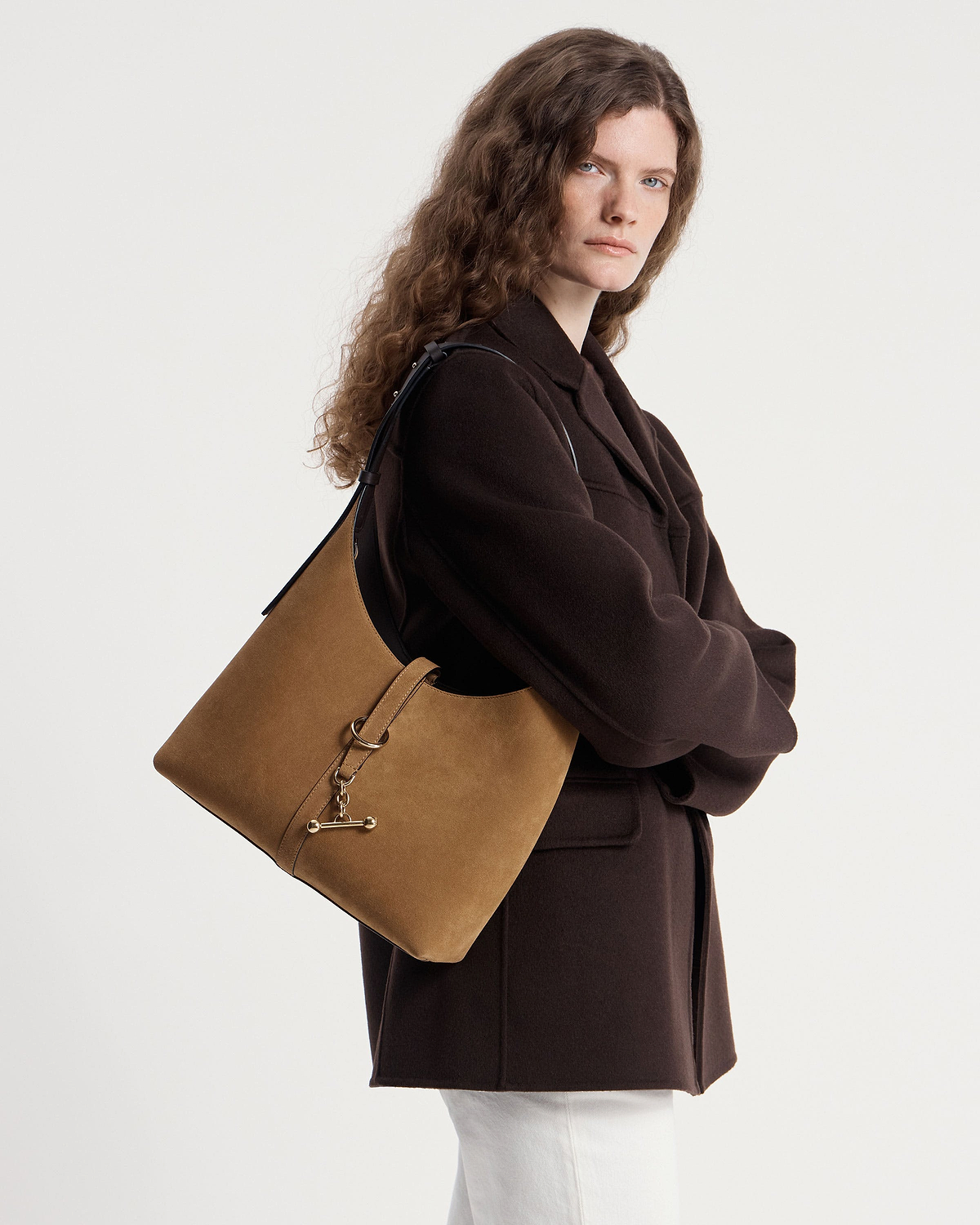 Model wearing a toffee suede and espresso kite hobo shoulder bag
