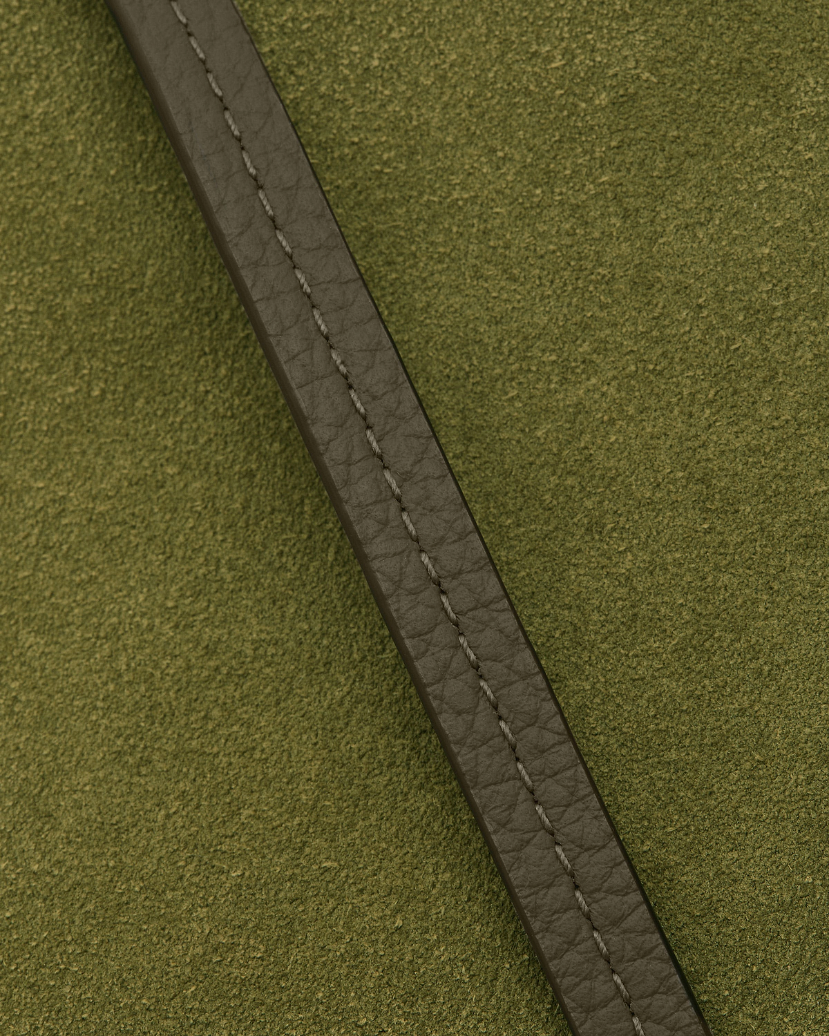 Khaki leather strap with stitching on lime suede textured pouch surface.