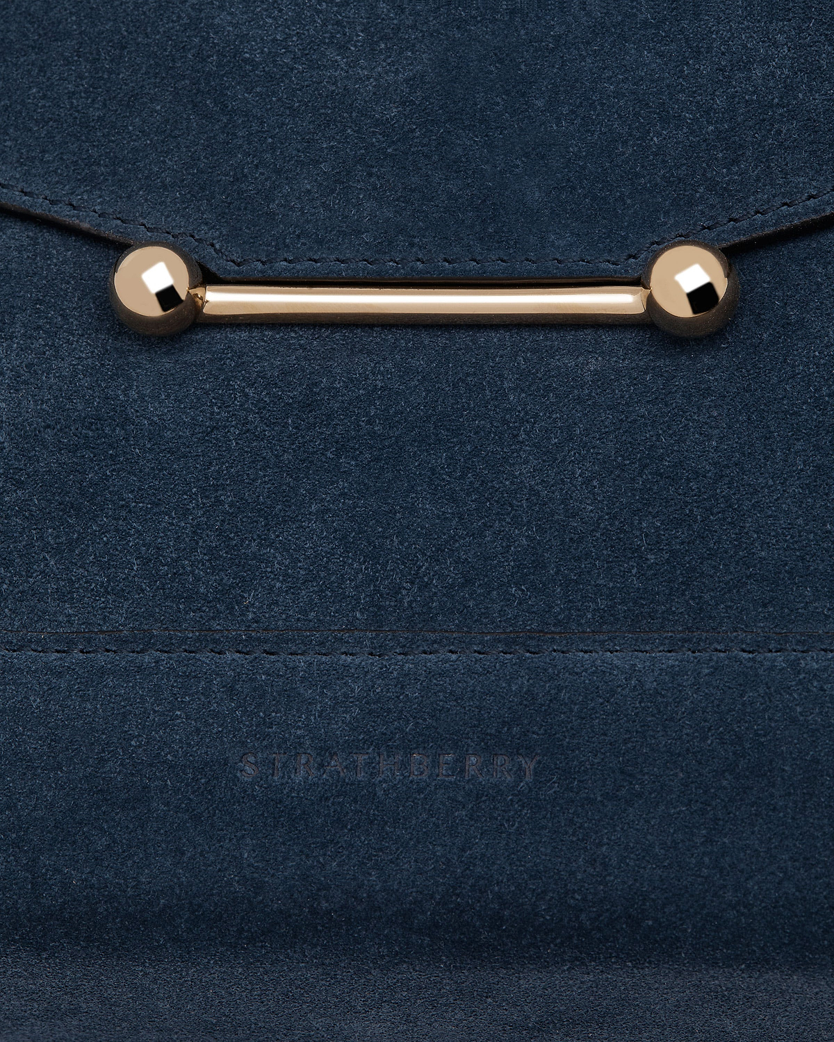 Loch blue suede mosaic bag close-up showing gold bar clasp and embossed Strathberry logo.