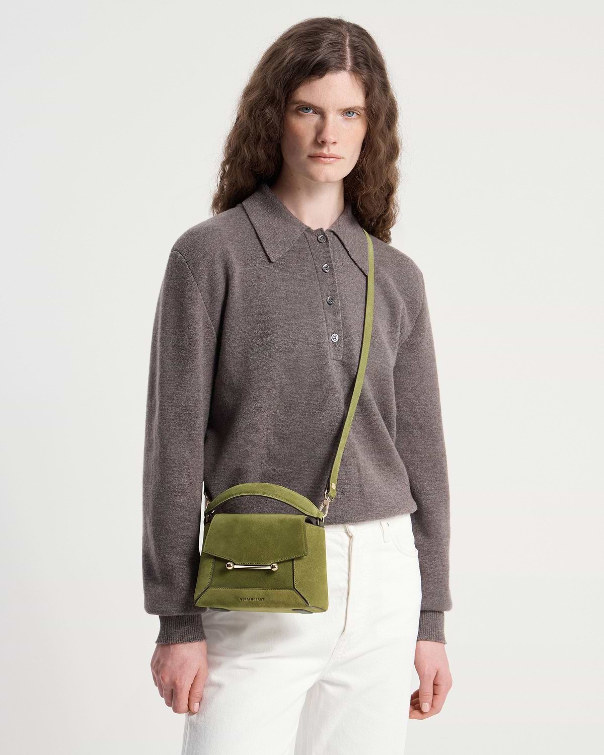 Model wearing Strathberry Mosaic Nano bag in lime suede, crossbody strap visible.