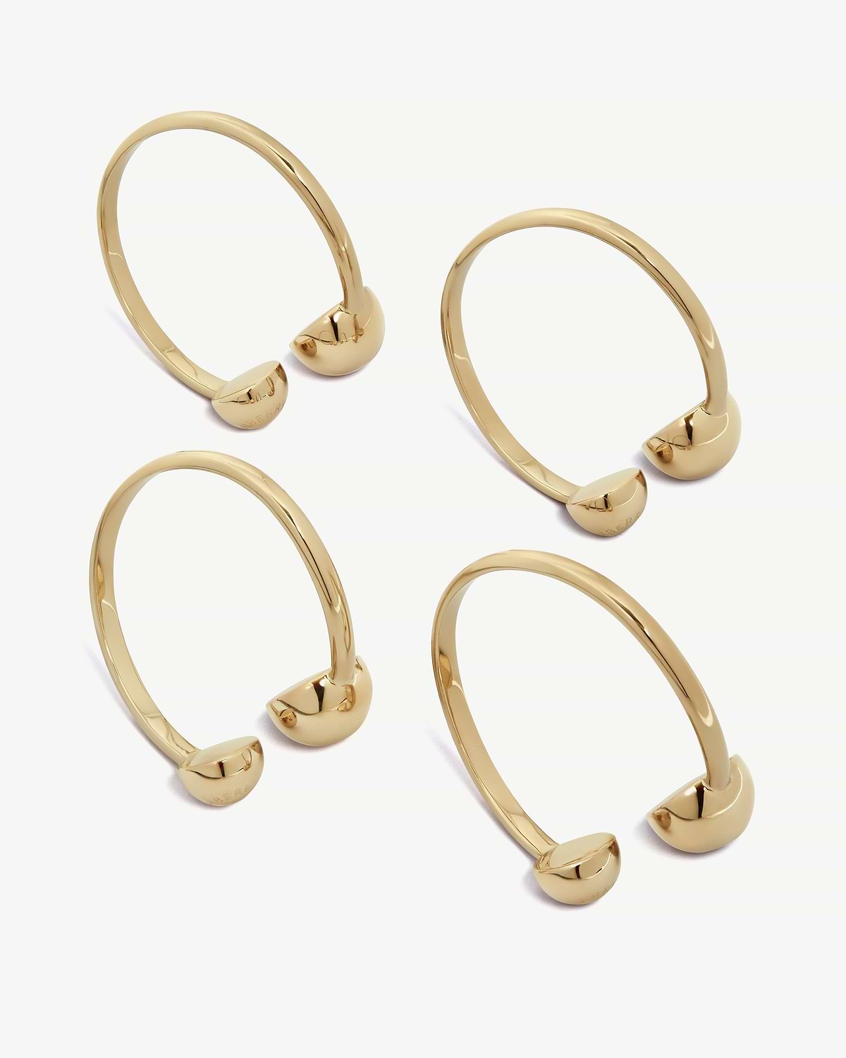Several light gold napkin rings arranged on a white background.