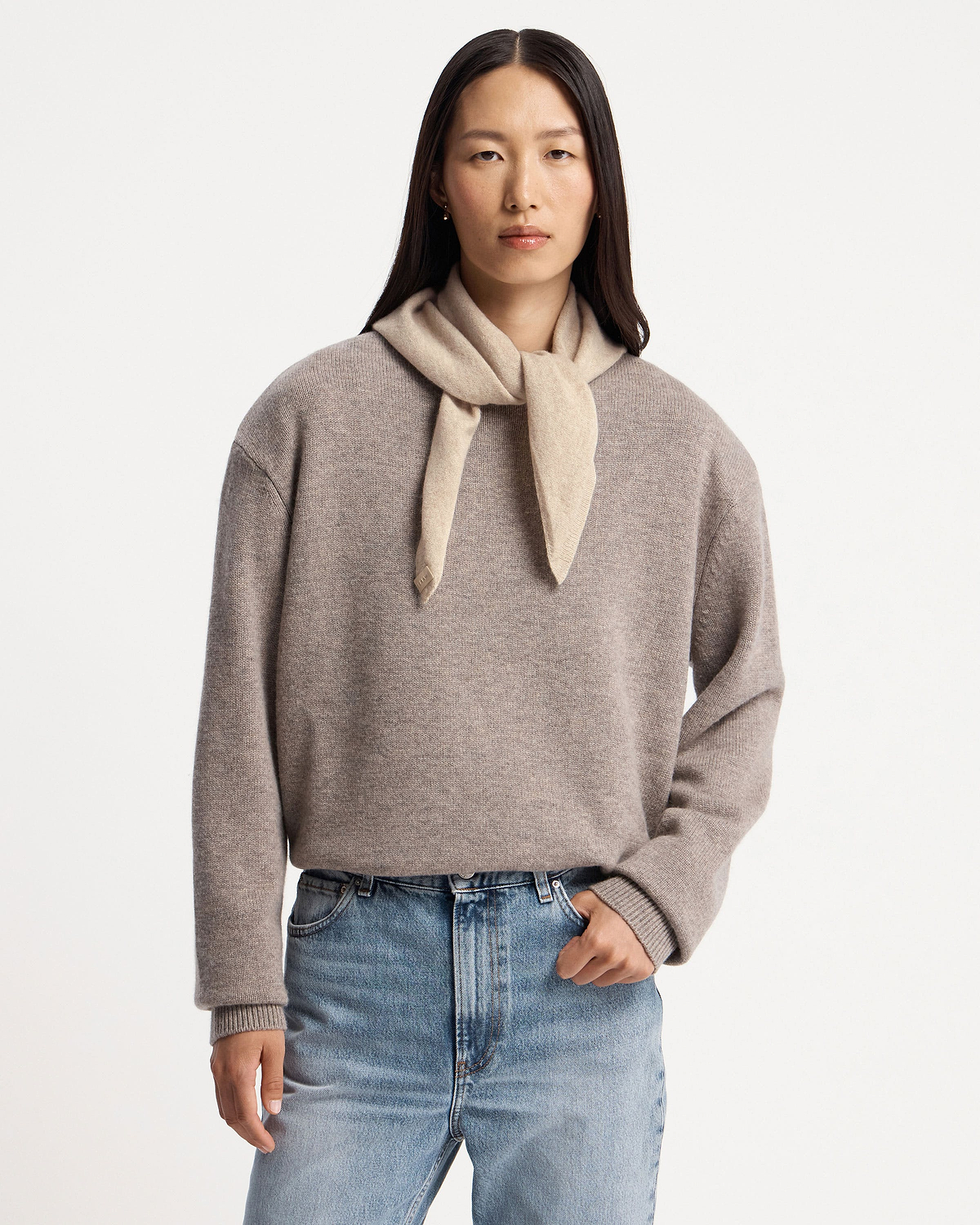 Model wearing an oat cashmere bandana tied at the neck and grey sweater.