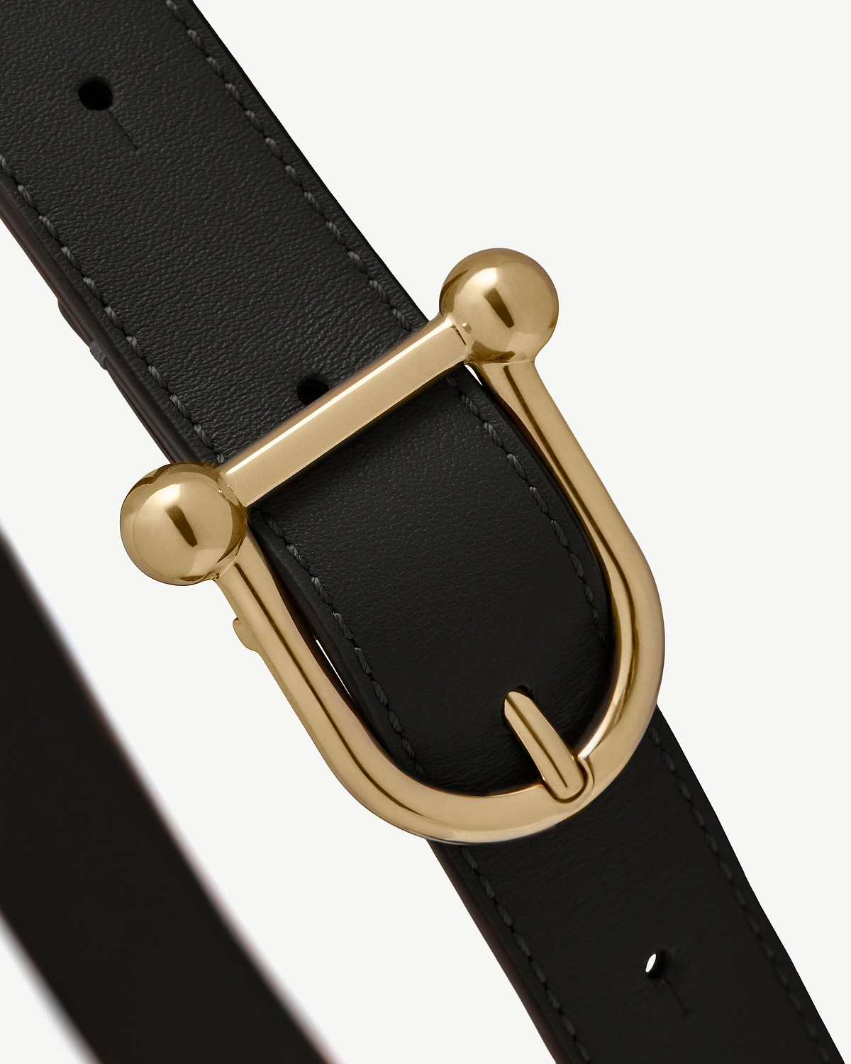 Black leather belt with gold metal buckle and visible stitching.