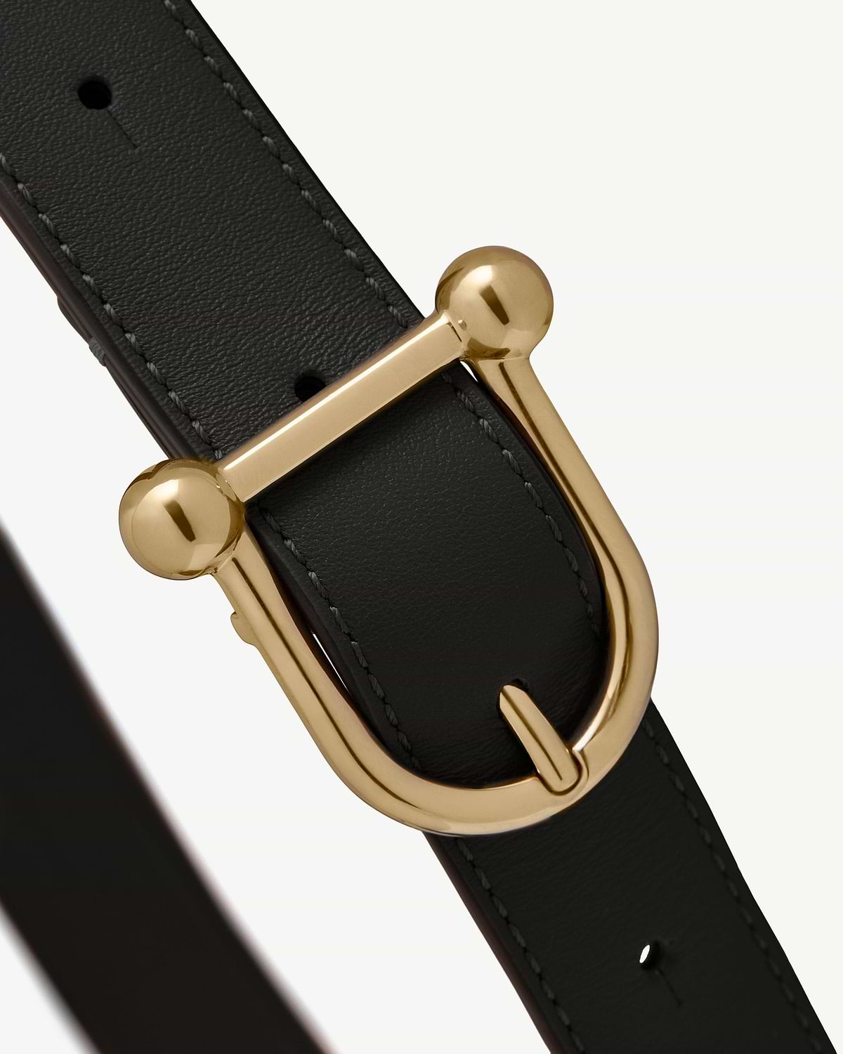 Black leather belt with gold metal buckle and visible stitching.