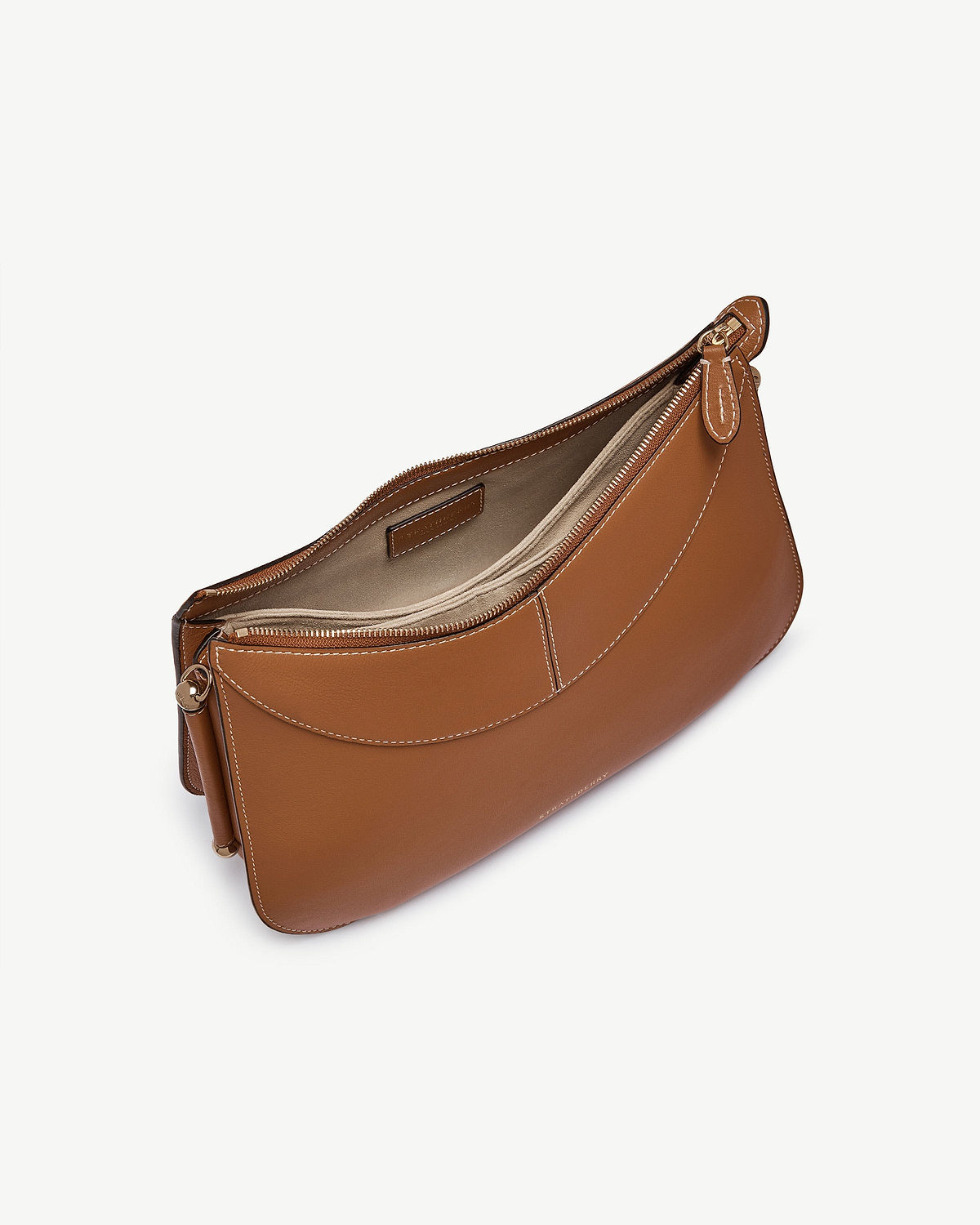 Tan leather shoulder bag with visible top zip, white stitching, curved front pocket.