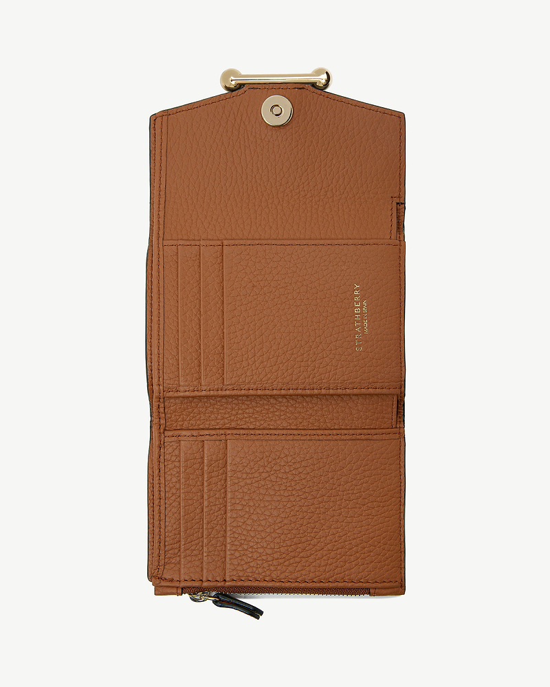 Tan leather trifold wallet open, showing card slots, zip pocket and Strathberry logo.