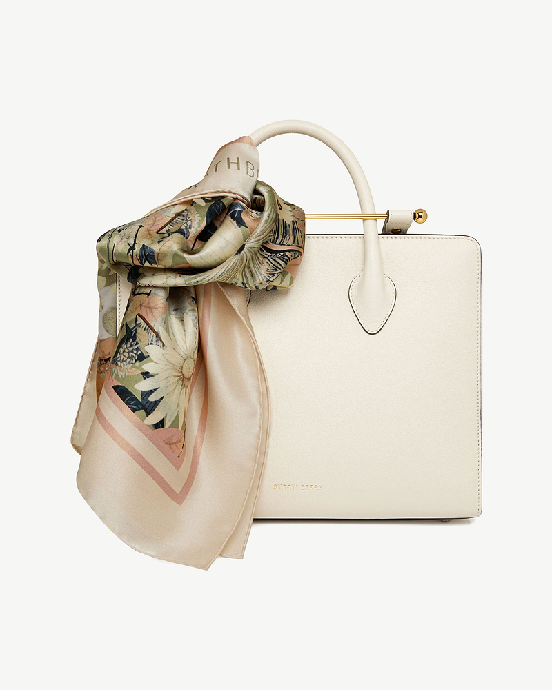 Autumn floral silk square scarf tied to cream Strathberry leather handbag.