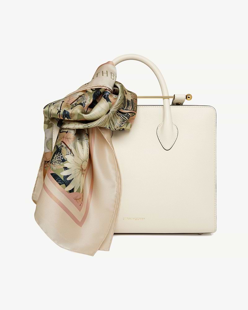 Autumn floral silk square scarf tied to cream Strathberry leather handbag.