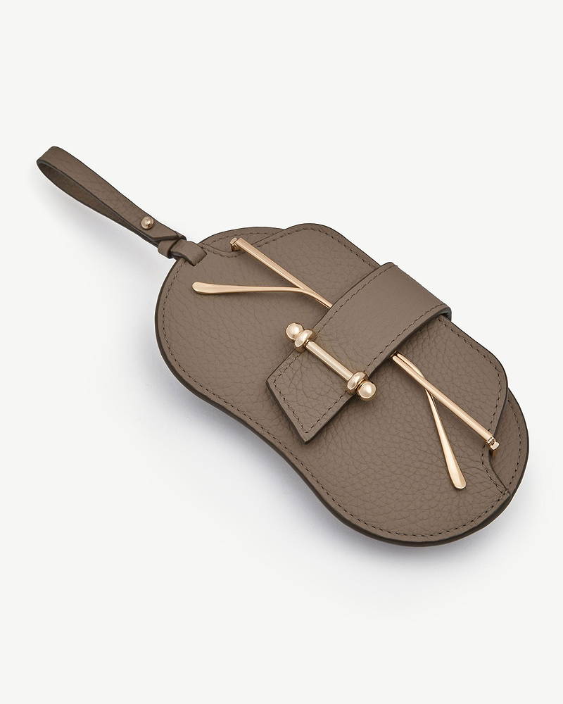 Taupe pebbled leather sunglasses case with gold hardware and wrist strap.