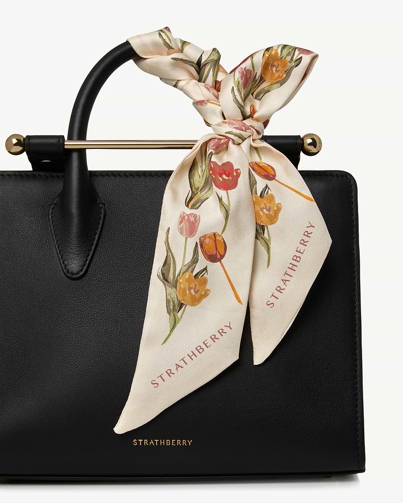 Vanilla tulip print silk skinny scarf tied to black Strathberry bag handle.