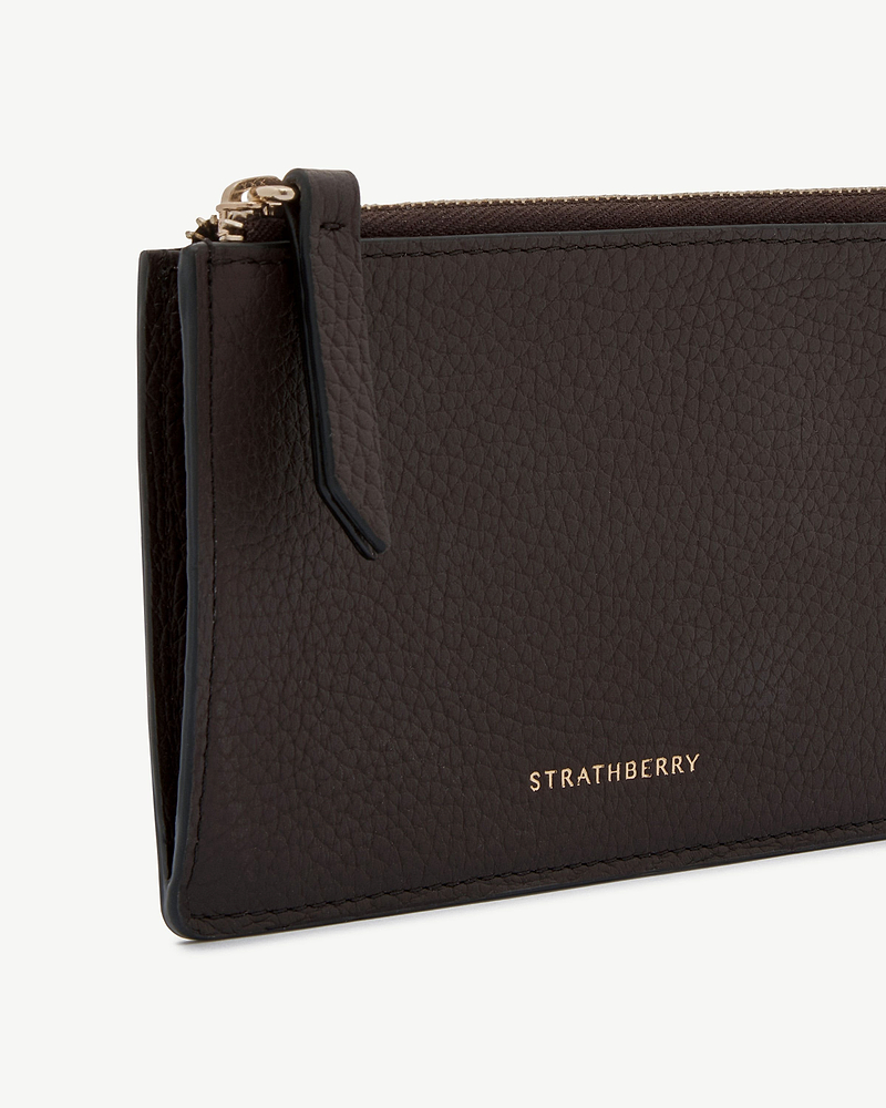 Espresso pebbled leather Charlotte purse showing gold Strathberry logo with zip pull visible