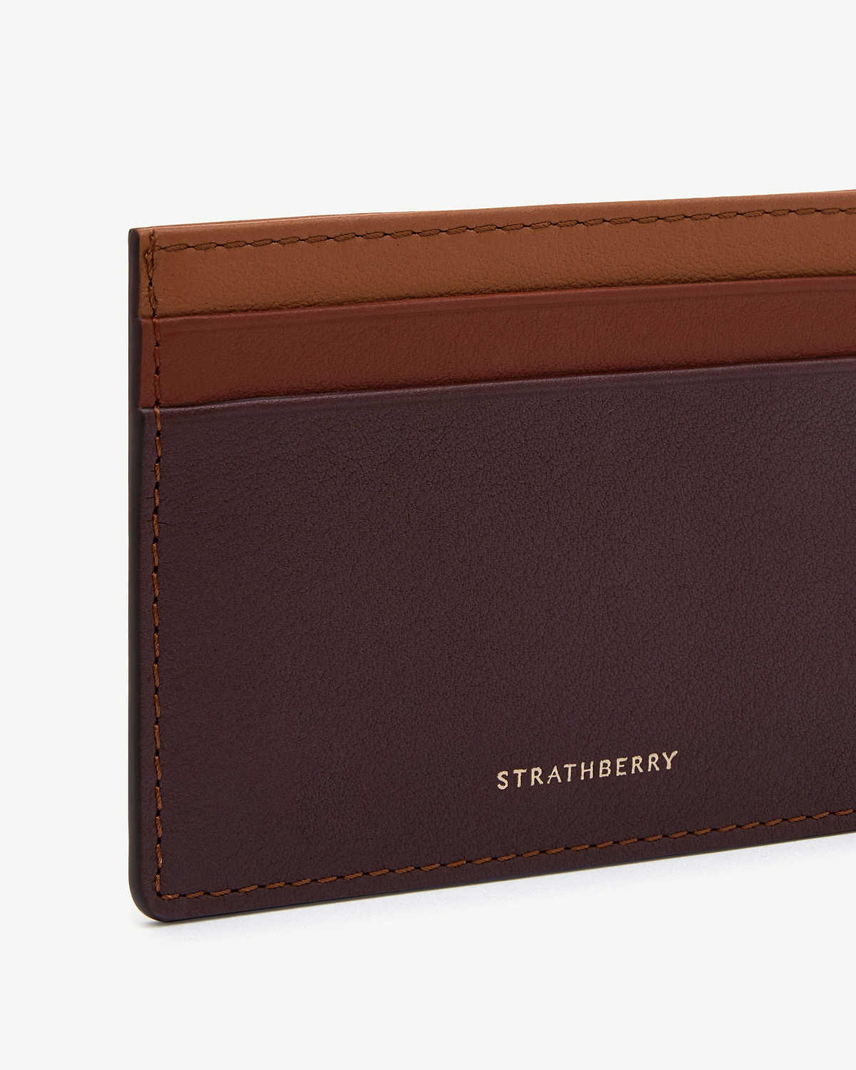 Strathberry burgundy, walnut and chestnut leather cardholder showing stitching and logo.