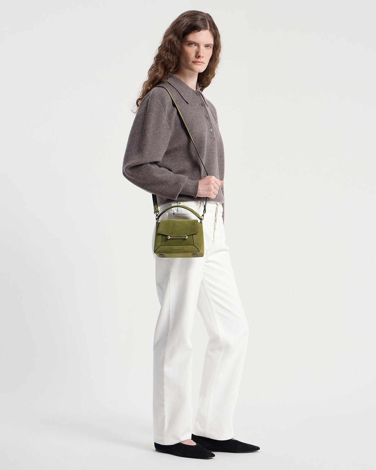 Model wearing lime suede and khaki Mosaic Nano crossbody bag with white trousers