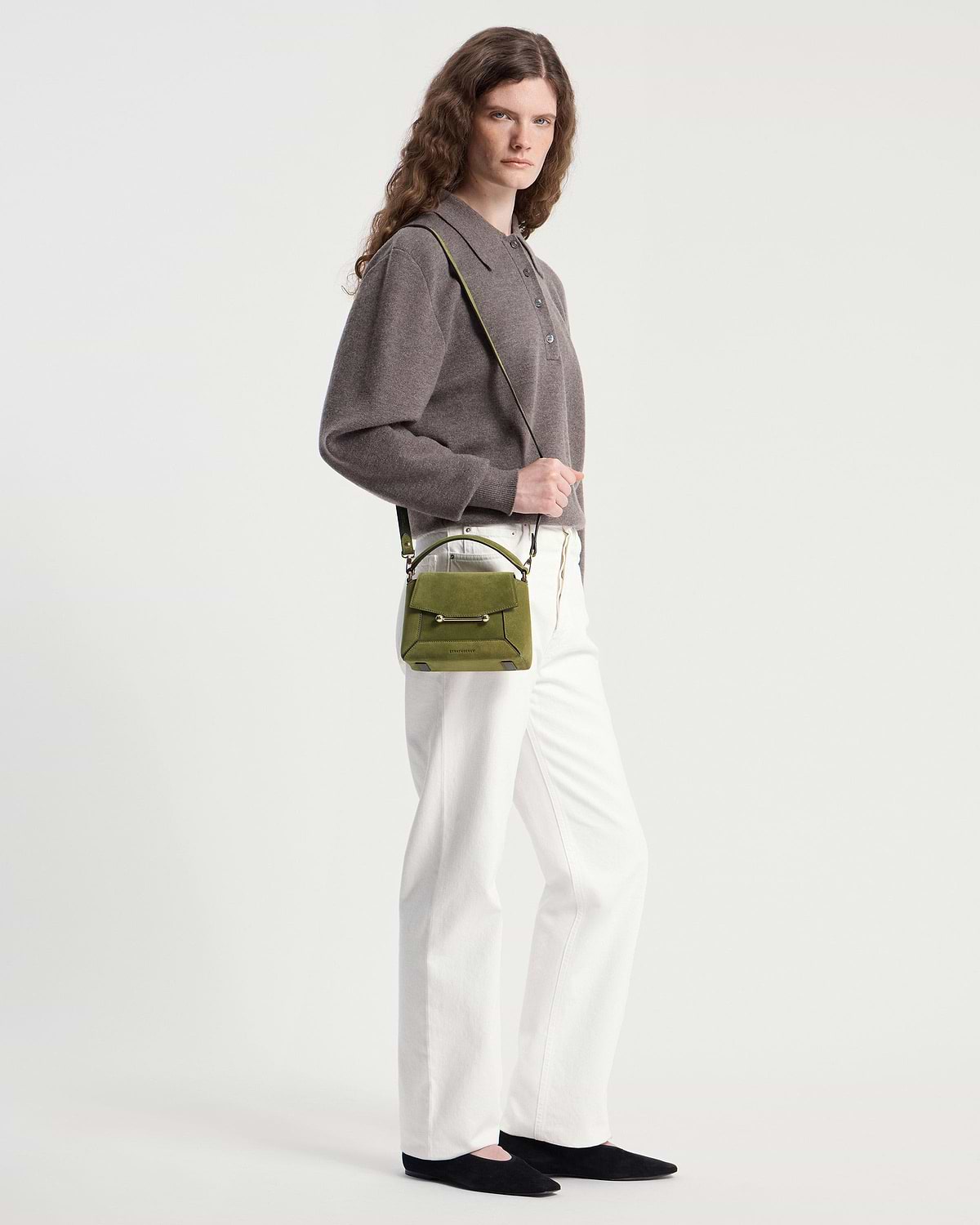 Model wearing lime suede and khaki Mosaic Nano crossbody bag with white trousers