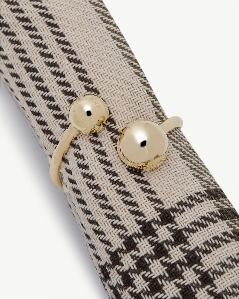 Woven napkin holder with light gold round clasp stamped Strathberry.