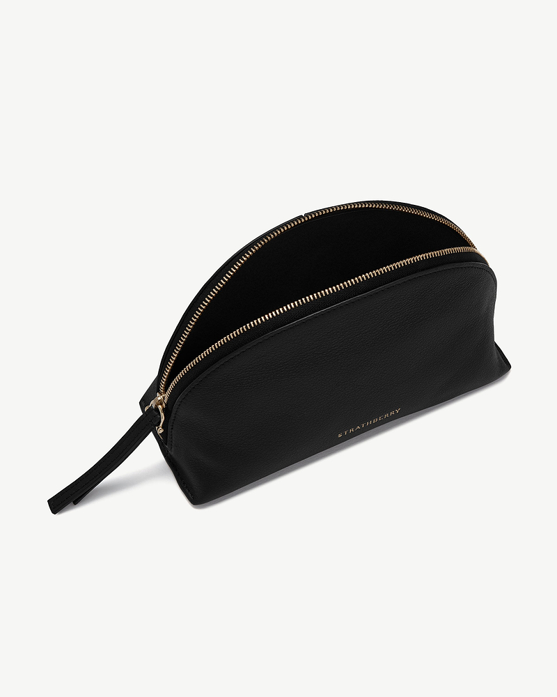 Black leather nest pouch with gold zip and Strathberry logo.