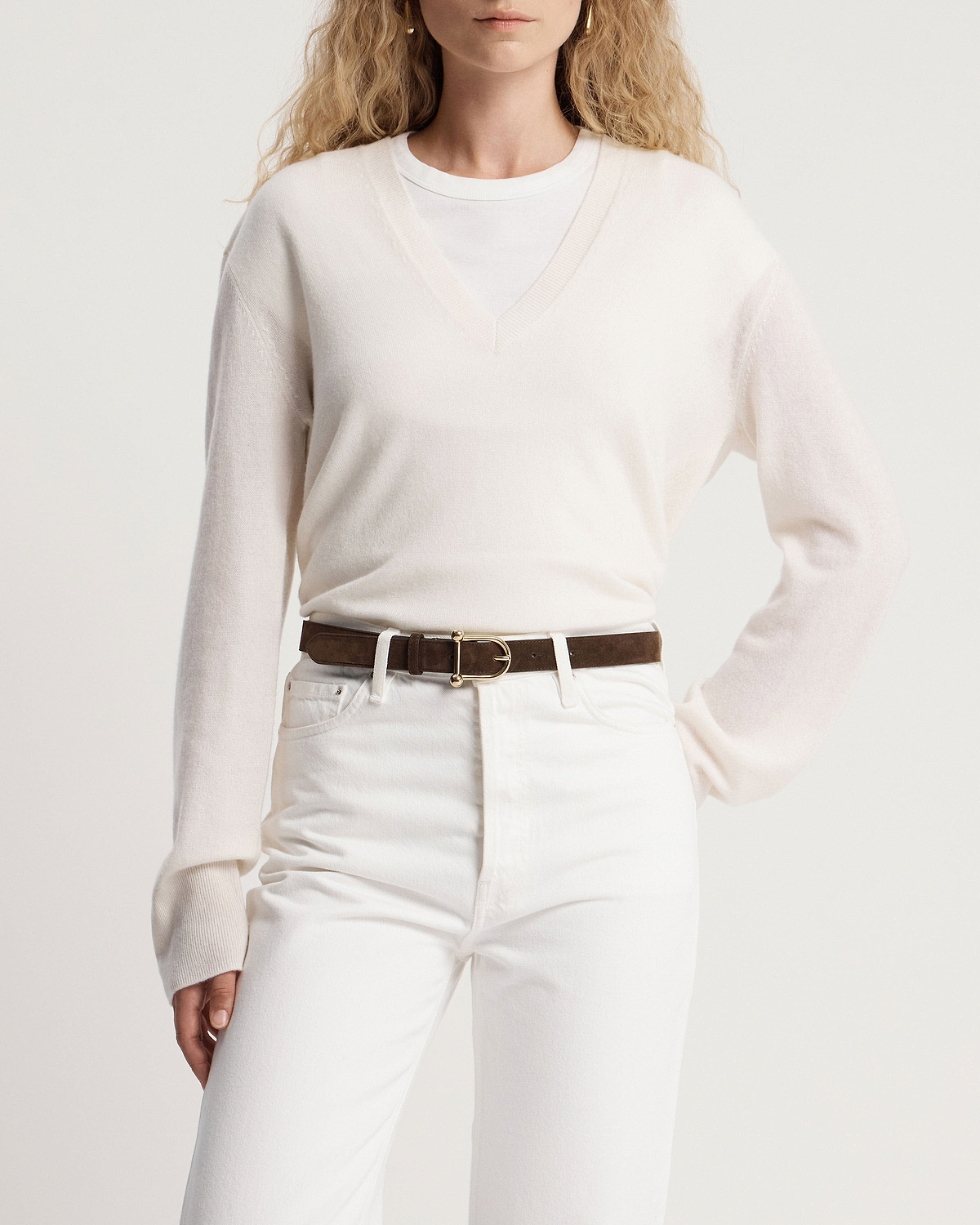 Model wearing white V-neck jumper and jeans with chocolate suede belt, gold buckle.