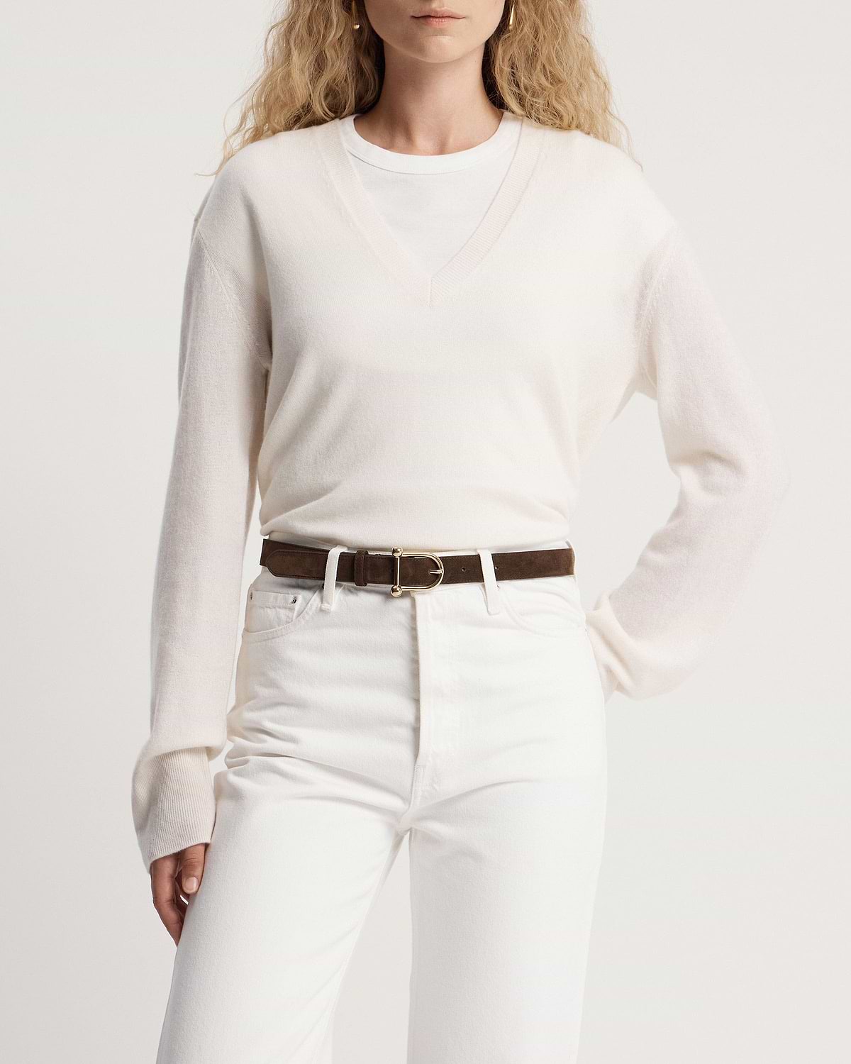 Model wearing white V-neck jumper and jeans with chocolate suede belt, gold buckle.